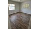 Bright bedroom features wood-look floors and large windows, creating a serene space at 406 Bullard Pkwy, Temple Terrace, FL 33617
