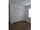 Cozy bedroom featuring wood-look flooring, closet, and a window at 406 Bullard Pkwy, Temple Terrace, FL 33617