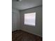 An empty room with wood-look laminate flooring, a window, and a closet with white, louvered doors at 406 Bullard Pkwy, Temple Terrace, FL 33617