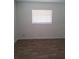 An empty bedroom featuring wood-look laminate flooring and a window with horizontal blinds at 406 Bullard Pkwy, Temple Terrace, FL 33617