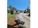 Wide angle view of house exterior with black garage door and long driveway at 406 Bullard Pkwy, Temple Terrace, FL 33617
