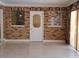 Living Room with brick and stone walls, ceramic flooring, and natural light from the glass block windows at 406 Bullard Pkwy, Temple Terrace, FL 33617