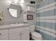 Well-maintained bathroom with a white vanity and blue-striped shower curtain at 4125 W Obispo St, Tampa, FL 33629