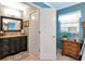 Bathroom featuring a granite countertop vanity, decorative mirror, and neutral-toned walls, creating a functional space at 4125 W Obispo St, Tampa, FL 33629