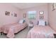 Light pink bedroom featuring two twin beds with matching patterned comforters at 4125 W Obispo St, Tampa, FL 33629