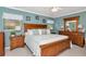 Serene bedroom with a large wooden bed, blue walls, soft lighting, and tasteful decor, creating a relaxing retreat at 4125 W Obispo St, Tampa, FL 33629