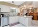 Charming kitchen with white cabinets, granite countertops, stainless appliances, and a breakfast bar adjacent to office at 4125 W Obispo St, Tampa, FL 33629