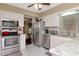 Well-lit kitchen with stainless steel appliances, white cabinets, and granite countertops overlooking a cozy sitting room at 4125 W Obispo St, Tampa, FL 33629
