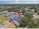 An aerial view of a home with a dark roof and a screened in pool, located in a suburban neighborhood at 4401 Arranmore Cir, Valrico, FL 33596