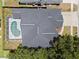 An aerial view shows a dark roof with a screened in pool, surrounded by a brown wooden fence at 4401 Arranmore Cir, Valrico, FL 33596