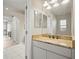 Bathroom featuring a granite countertop, decorative mirror, and lots of light at 4401 Arranmore Cir, Valrico, FL 33596
