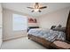 This bedroom features a bed, window, ceiling fan, and neutral walls and carpet at 4401 Arranmore Cir, Valrico, FL 33596