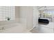 This main bathroom features white cabinets, a granite vanity, a soaking tub, and an ensuite bathroom at 4401 Arranmore Cir, Valrico, FL 33596
