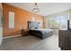 The main bedroom features a decorative orange accent wall, hardwood floors, and bright natural light at 4401 Arranmore Cir, Valrico, FL 33596