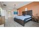 The main bedroom features a decorative orange accent wall, hardwood floors, and ensuite bathroom at 4401 Arranmore Cir, Valrico, FL 33596