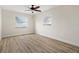 Bright, empty bedroom with a ceiling fan, two windows, wood look floors, and neutral colors at 4549 Ontario Dr, New Port Richey, FL 34652