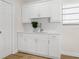 Bright kitchenette featuring white cabinetry, stone countertops, subway tile backsplash and stainless steel hardware at 4549 Ontario Dr, New Port Richey, FL 34652