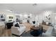 Open-concept living area flows into kitchen and dining, featuring sleek modern decor, wood floors, and white accents at 4549 Ontario Dr, New Port Richey, FL 34652