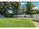 Lush, green backyard with a white vinyl fence offering privacy and a well-manicured lawn and tropical trees at 4918 Lakeshore Oaks Ct, Tampa, FL 33624