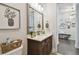 Bathroom featuring a dark wood vanity, a large mirror, and decorative wall art at 4918 Lakeshore Oaks Ct, Tampa, FL 33624
