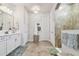 Bathroom featuring double sinks, a chandelier, and a glass-enclosed shower at 4918 Lakeshore Oaks Ct, Tampa, FL 33624