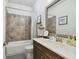 Neutral toned bathroom featuring vanity sink with dark wood cabinet, shower-tub, and modern fixtures at 4918 Lakeshore Oaks Ct, Tampa, FL 33624