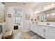 Bright bathroom features double vanity with white cabinetry, quartz countertops, and tile floors at 4918 Lakeshore Oaks Ct, Tampa, FL 33624