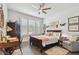 Cozy bedroom featuring a comfortable bed, plantation shutters, a ceiling fan, and ample natural light at 4918 Lakeshore Oaks Ct, Tampa, FL 33624
