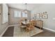 Bright dining room features modern light fixture, hardwood floors, decorative rug, and shuttered windows at 4918 Lakeshore Oaks Ct, Tampa, FL 33624