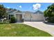 Charming single-Gathering home with a well-manicured lawn and a two-car garage under a sunny sky at 4918 Lakeshore Oaks Ct, Tampa, FL 33624