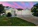 Charming single-Gathering home with a well-manicured lawn and a two-car garage against colorful sky at 4918 Lakeshore Oaks Ct, Tampa, FL 33624