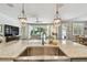 Kitchen island with stainless sink and granite countertops overlooking the living area at 4918 Lakeshore Oaks Ct, Tampa, FL 33624