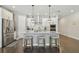 Modern kitchen featuring an island with seating, stainless steel appliances, and white cabinets at 4918 Lakeshore Oaks Ct, Tampa, FL 33624