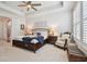 Main bedroom with tray ceiling, ceiling fan, and a chair and ottoman at 4918 Lakeshore Oaks Ct, Tampa, FL 33624