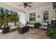 Covered patio with comfortable seating, ceiling fan, and stylish decor creating a relaxing outdoor entertainment area at 4918 Lakeshore Oaks Ct, Tampa, FL 33624