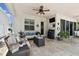 Relaxing covered patio featuring comfortable seating, a ceiling fan, an outdoor tv and neutral decor at 4918 Lakeshore Oaks Ct, Tampa, FL 33624