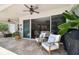 Covered patio with comfortable seating, ceiling fans, sliding glass doors, and a barbecue, creating an ideal outdoor space at 4918 Lakeshore Oaks Ct, Tampa, FL 33624