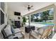 Comfortable patio seating with an outdoor tv and ceiling fan; perfect for relaxing and entertaining at 4918 Lakeshore Oaks Ct, Tampa, FL 33624