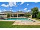 Backyard with a sparkling pool featuring a travertine deck and well-maintained lawn, perfect for outdoor living at 4918 Lakeshore Oaks Ct, Tampa, FL 33624