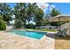 Backyard featuring a sparkling blue swimming pool with patio and lounging chairs at 4918 Lakeshore Oaks Ct, Tampa, FL 33624