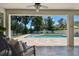 Inviting covered patio with a ceiling fan overlooking a beautiful in-ground pool and spacious backyard at 4918 Lakeshore Oaks Ct, Tampa, FL 33624