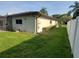 View of the home's exterior, showcasing the well-kept lawn and landscaping, plus partial view of screened patio at 50 Water Oak Way, Oldsmar, FL 34677