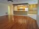 Open-concept living area with hardwood floors flowing into a kitchen featuring bright cabinets at 50 Water Oak Way, Oldsmar, FL 34677
