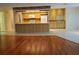 Open-concept living area with hardwood floors flowing into a kitchen featuring bright cabinets and tile floors at 50 Water Oak Way, Oldsmar, FL 34677