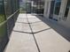This is a partially shaded view of a large screened-in patio with room for outdoor dining or entertaining at 50 Water Oak Way, Oldsmar, FL 34677