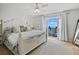 Bright bedroom featuring a white bed and patio doors leading to a balcony with water views at 5042 Coquina Key Se Dr, St Petersburg, FL 33705
