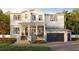 Charming two-story home featuring a covered front porch, a two car garage, and manicured lawn at 530 Severn Ave, Tampa, FL 33606
