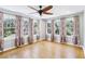 Bright bedroom with hardwood floors and large windows dressed with patterned curtains at 5632 Indiana Ave, New Port Richey, FL 34652