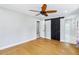 Large bedroom with hardwood floors, ceiling fan and barn door leading to the bathroom at 5632 Indiana Ave, New Port Richey, FL 34652