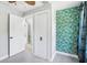 Bright bedroom featuring closet and accent wall with tropical patterned wall paper at 5632 Indiana Ave, New Port Richey, FL 34652
